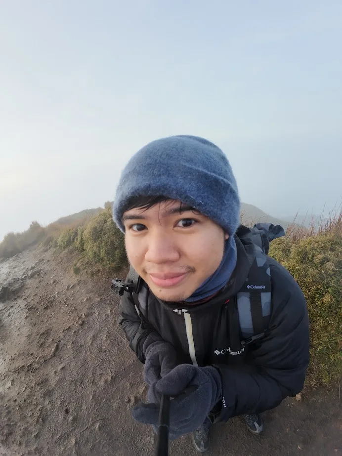 Gabriel Tibay on a foggy mountain trail, grinning into a selfie